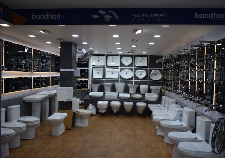 Wide view of the Bandhan sanitaryware hall — wall-mounted basins in a grid, floor-standing water closets down both sides
