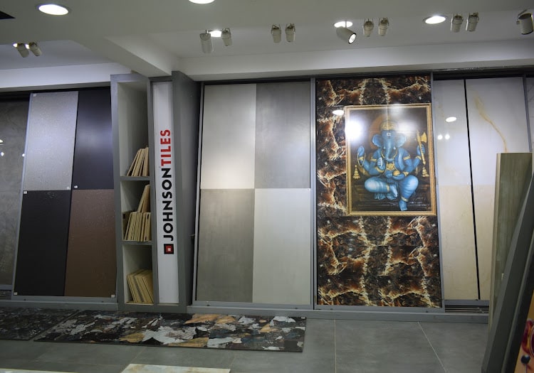 Johnson Tiles display wall with large-format panels and a framed Ganesha tile mural set into the marble-effect surround