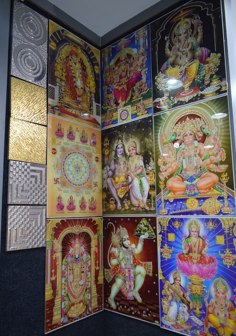 Corner display of printed deity tiles for pooja rooms beside textured metallic wall tiles