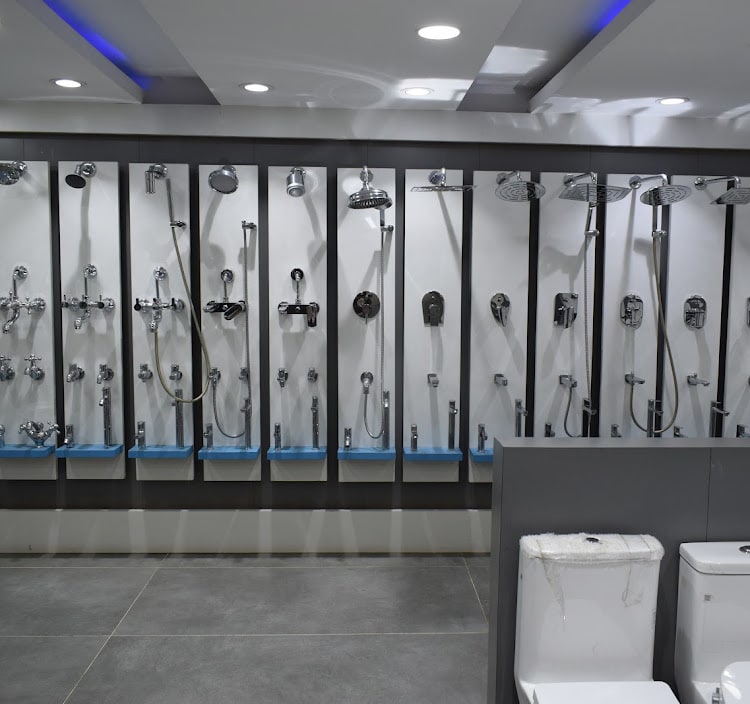 Shower and mixer sets mounted on white display columns with hand showers and health faucets on each panel