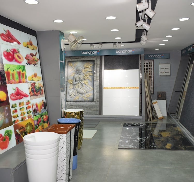 Tile gallery with a printed fruit-and-vegetable kitchen range on the left, a carved wall mural panel ahead and polished marble slabs on the floor