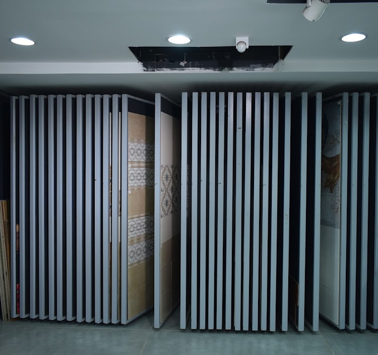 Vertical swing racks holding full-size tile samples, one panel pulled out to show a patterned range