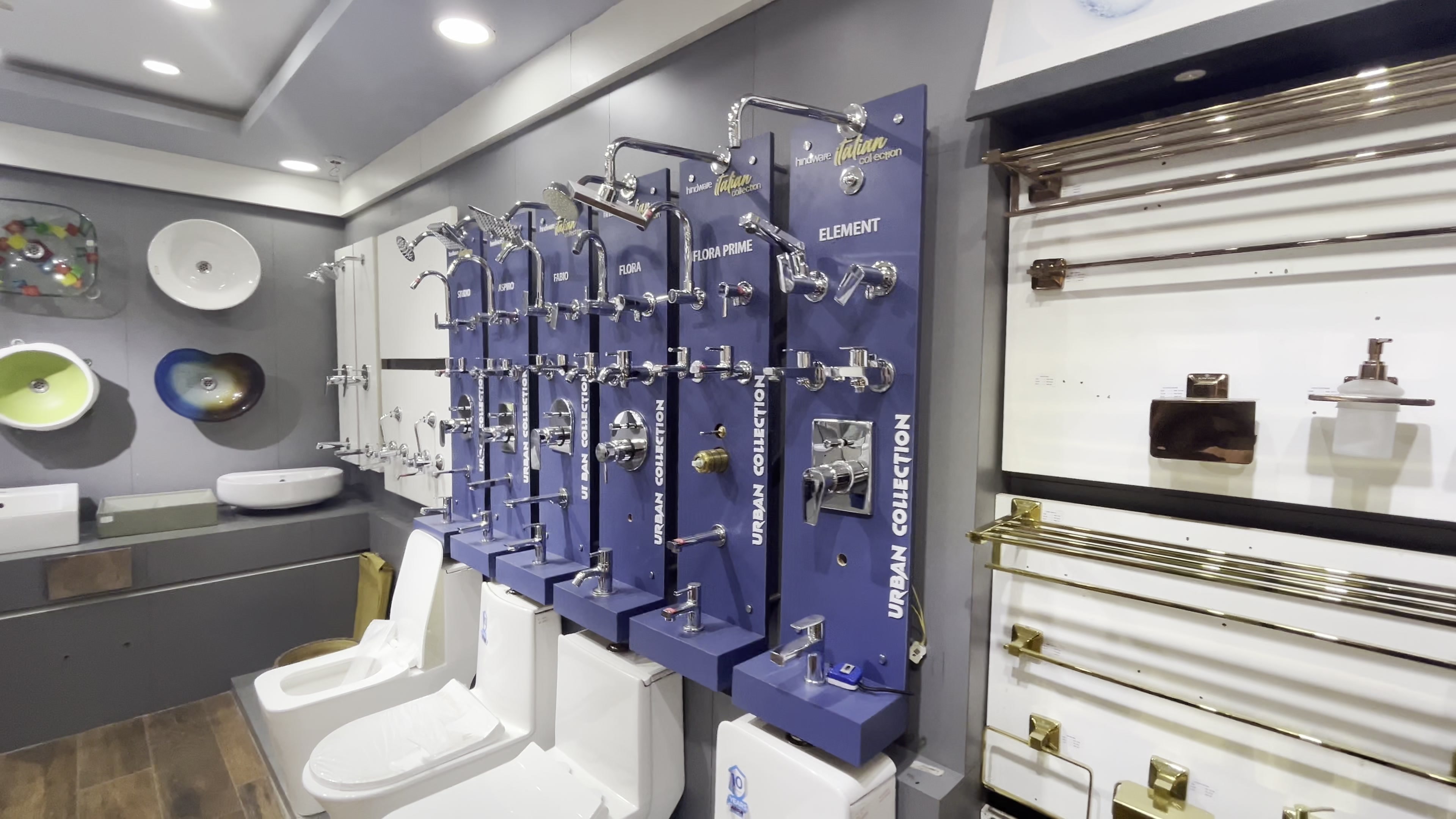 Wall mixers and shower arms mounted across the bath fittings display